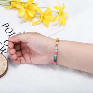 Colorful agate stone beads bracelet shown on a female wrist in a stylish home setting