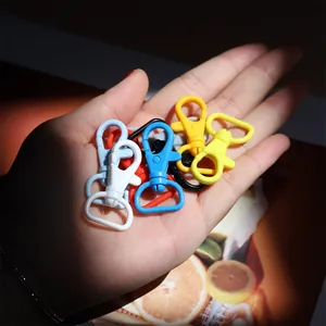 Hand holding candy-colored 40mm plastic swivel lobster clasps for DIY jewelry making