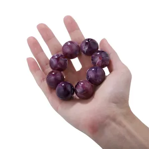 Close-up of 16-20mm purple marble textured chalcedony beads held in hand for scale