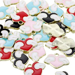 Macro shot of colorful enamel winged heart charms with gold plating for DIY jewelry making