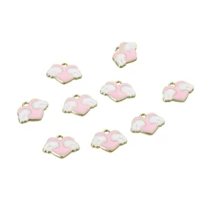 Macro shot of light pink heart pendants with white wings and golden alloy edges for DIY
