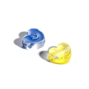 Close-up of heart-shaped acrylic beads with smile and lightning bolt for DIY jewelry