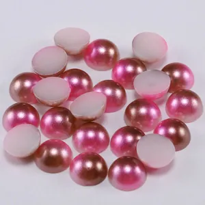 Macro view of metallic pink and bronze flatback resin half-pearls for DIY crafts