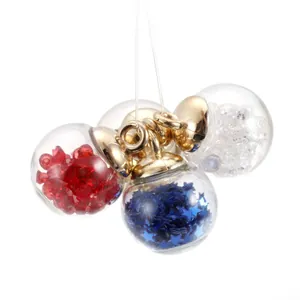Detail showing four star-filled glass ball charms with golden metal caps and loops