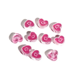 Detail of pink acrylic heart beads with white smiley faces for DIY jewelry making