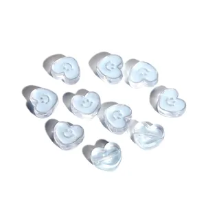 Macro detail of heart-shaped light blue acrylic beads with smiley face for DIY jewelry