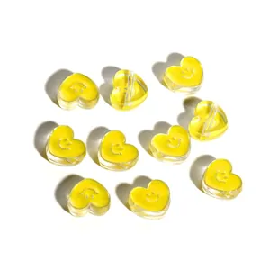 Macro detail of yellow transparent heart-shaped beads with cute smiley face patterns