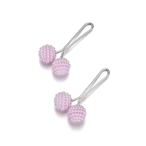 Close-up of pink beaded sphere shawl clips with silver U-shaped metal pins