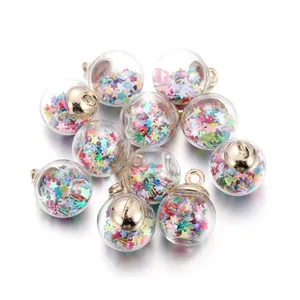 Close-up of clear glass ball pendants filled with colorful star-shaped sequins and gold hooks