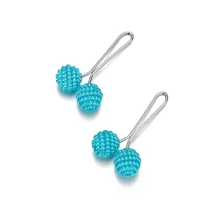 Macro shot of two teal textured bead hijab pins with silver-toned U-shaped steel needles