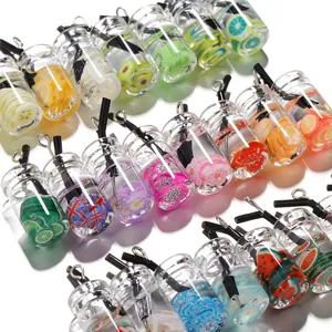 Détail de mini bouteilles en verre avec tranches de fruits assorties et pendentifs