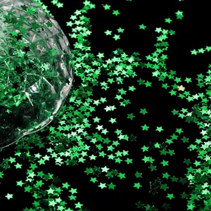 Macro di paillettes a forma di stella verde smeraldo su uno sfondo nero