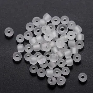 Detalle macro de cuentas de vidrio blanco mate de 3 mm con agujero central para joyas