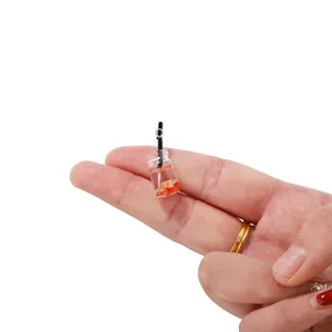 Détail d'un mini pendentif bouteille de thé à l'orange avec paille et anneau