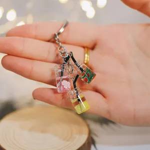 Détail de pendentifs mini bouteilles de jus de fruits avec citrons et pastèques