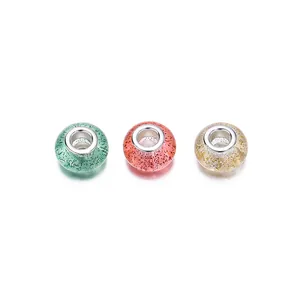Detalle macro de cuentas de resina con lentejuelas brillantes y núcleos de plata para joyas