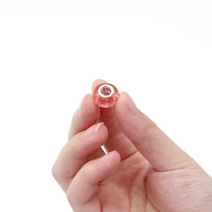 Detalle de cuenta de resina rosa con purpurina roja y núcleo metálico para pulseras