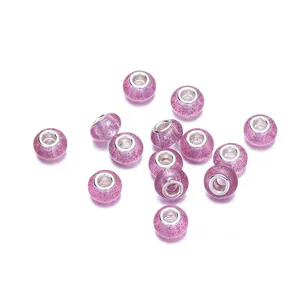 Detalle macro de cuentas de resina violeta brillante con núcleos de metal para joyería DIY