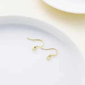 Primer plano de ganchos para pendientes DIY bañados en oro de 18K con cuentas decorativas
