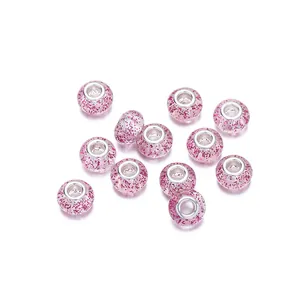 Detalle de cuentas de resina con purpurina rosa y núcleo de metal para pulseras de bricolaje
