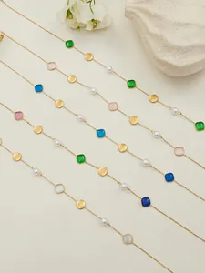 Λεπτομέρεια από επιχρυσωμένες αλυσίδες 18k με χρωματιστά μενταγιόν και πέρλες