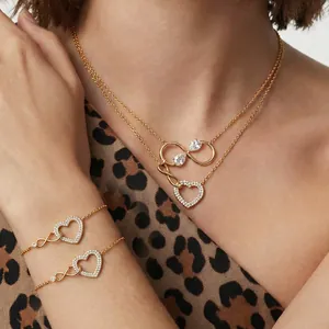 Parure de bijoux dorés avec symboles de cœur et infini sur fond à imprimé léopard