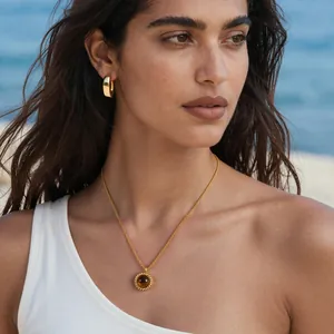 Collier avec pendentif oeil de tigre doré 18 carats et créoles portés par un mannequin