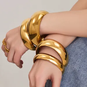 Bracelets et bagues en acier inoxydable plaqué or 18k polis présentés sur un mannequin