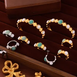 Gold and silver jewelry set with green oval stones in a velvet box organizer