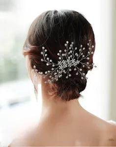 Detailed back view of a silver bridal hair comb with rhinestones and pearls on a bun