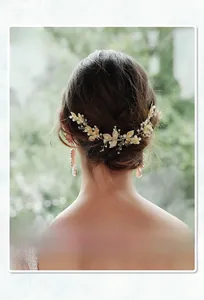 Elegant bridal hair comb detail featuring golden alloy leaves and white pearls for weddings