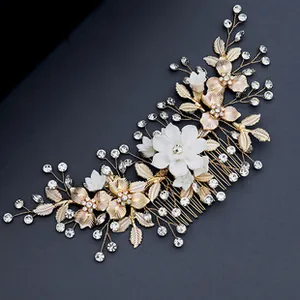 Detail of bridal hair comb with gold leaves, white flowers and sparkling rhinestones