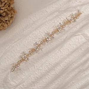 Bandeau de mariée or rose avec perles, strass et rubans blancs sur fond à texture élégante