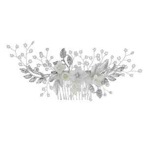 Elegante bruidshaarkam met keramische bloemen, parels en kristallen op wit decor
