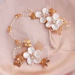 Detailsicht der goldenen Braut-Haarkämme mit weißen Muschelblüten und Perlen