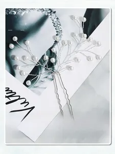 Close-up of handmade bridal hair pins with white pearls and woven silver wire branches