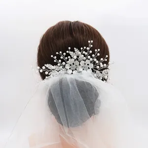 Peigne à cheveux de mariée floral argenté avec perles et strass sur un voile blanc