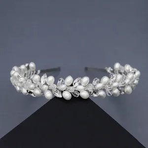 Détail de perles blanches ovales et cristaux facettés sur un serre-tête de mariée