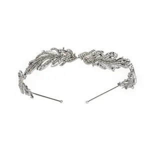 Macro detail of silver leaf headband featuring intricate rhinestone feather patterns