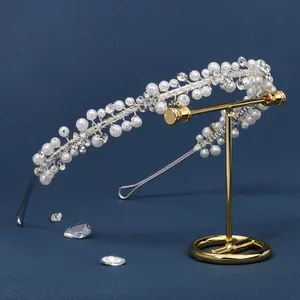 Détail d'un serre-tête en perles et strass argentés sur un support pour mariages