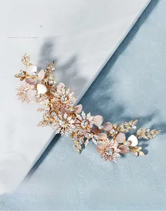 Macro detail of handmade gold flower hair clip with rhinestones and white petals