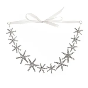 Detail of sparkling rhinestone snowflake headband with elegant white satin ribbon ties
