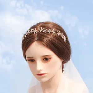 Elegant gold star rhinestone bridal headband displayed on mannequin with white veil and sky background