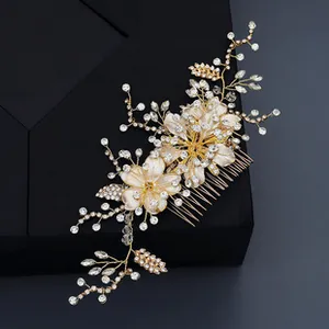 Detailed view of handmade floral hair comb with gold wires, crystals and white petals