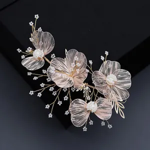 Close-up of pink mesh floral bridal hair comb with gold wire and pearl beads on black box