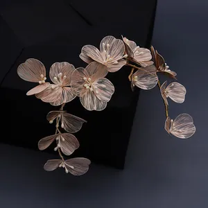 Detailed macro view of golden floral hairpiece with translucent petals and pearl accents