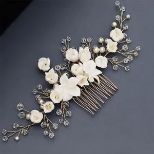 Detail view of handmade white flower hair comb with pearls and rhinestones on gold wire