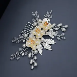 Detailed view of handmade bridal hair comb with cream flowers and white pearls