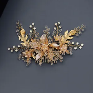 Detail of handmade gold bridal hair comb with crystal flowers and pearl beaded leaves