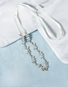 Détail du bandeau de mariée avec feuilles de cristal, perles et rubans blancs